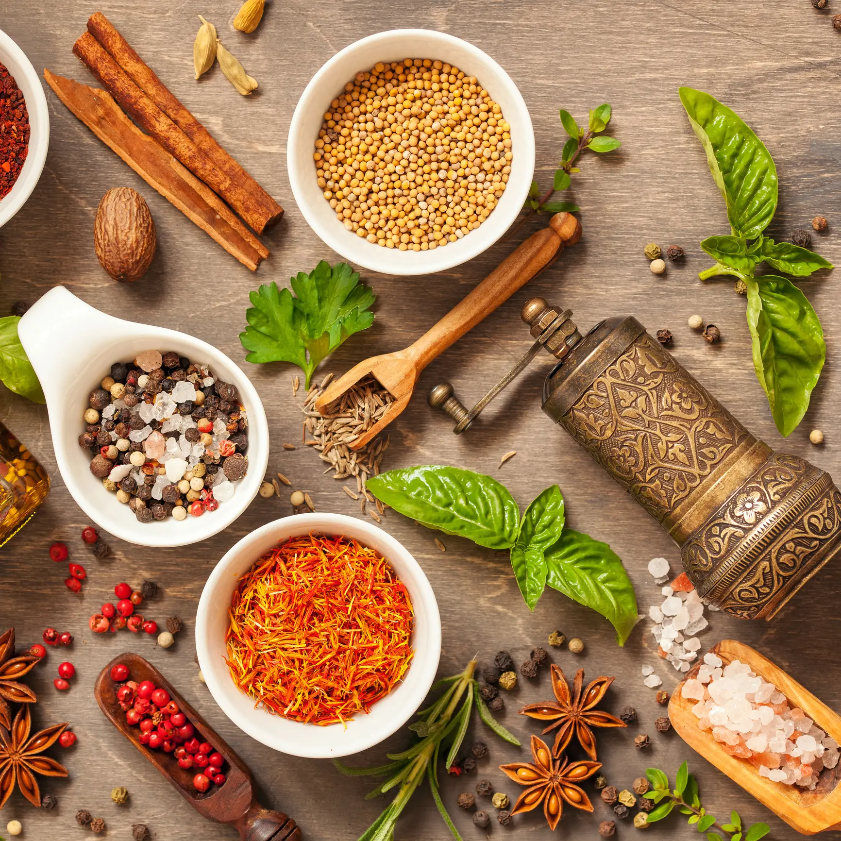 Spice and herb seasoning with fresh and dried herbs and spices in bowls on rustic wooden background. Flat lay. Top view.
